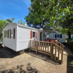 Terrasse ombragée avec rampe et arbres mobilhome du Camping Les Salisses à Vias Plage
