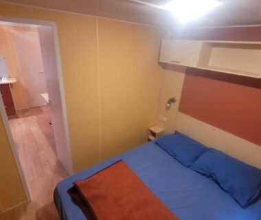Chambre avec lit double et couette bleue dans le mobil-home du Vias-Plage Camping Les Salisses