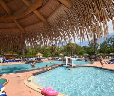Piscine extérieure avec parasols et transats au camping Vias-Plage Les Salisses Quality Holidays