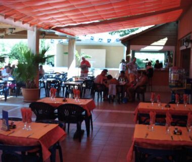 Terrasse couverte avec tables et chaises au Camping Les Salisses Quality Holidays