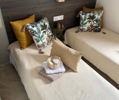 Chambre avec deux lits coussins et linge décoratif au View and Dream