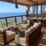 Terrasse lounge en bois avec vue mer au camping View and Dream