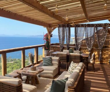 Terrasse en bois avec banquettes et vue sur la mer au camping View and Dream