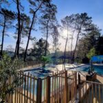Piscine extérieure entourée de pins au Village de Chalets