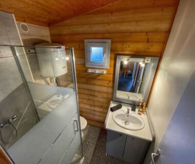 Salle de bain avec douche et lavabo dans le Village de Chalets