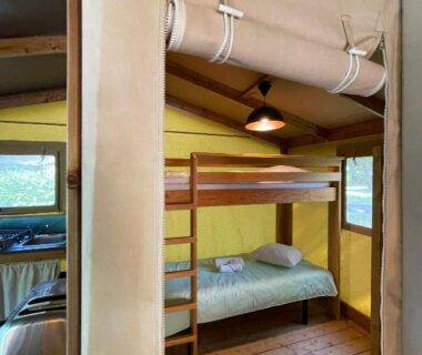 Intérieur de tente avec lits superposés et plancher en bois dans le Village loisirs de Goule