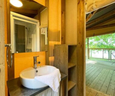 Salle d'eau avec lavabo et terrasse en bois au Village loisirs de Goule