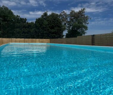 Piscine extérieure entourée de palissades et d'arbres au Village loisirs de Goule