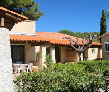 Terrasse ombragée avec table et jardin du Village vacances et camping de Gruissan