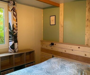 Chambre avec lit et fenêtre dans les Villages de Chalets et camping La Pierre de l'Aigle