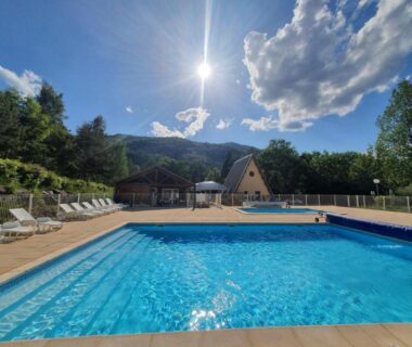 Piscine extérieure et transats en Alpes-de-Haute-Provence aux Villages de Chalets et camping La Pierre de l'Aigle