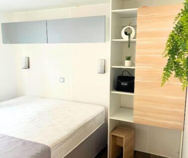 Chambre avec lit et rangements à Villages de Chalets et camping La Pierre de l'Aigle