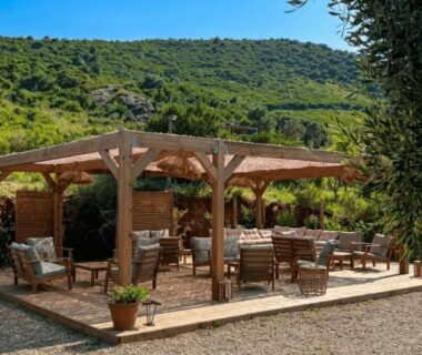 Terrasse ombragée avec tables et chaises dans le Cap Corse au camping Vista Mare