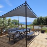 Terrasse ombragée avec salon et vue mer au camping Voltaire