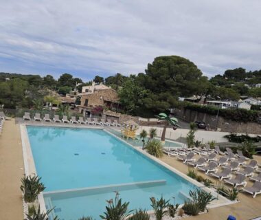 Piscine extérieure avec chaises longues au camping Voltaire