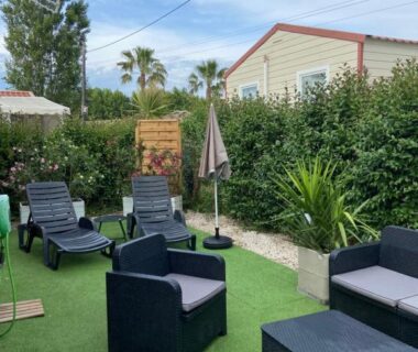 Terrasse avec transats fauteuils et parasol dans le camping Vos meilleures vacances au Montourey