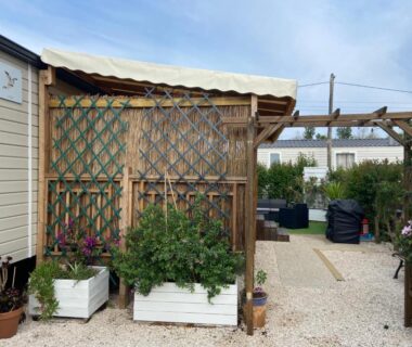Allée et terrasse avec jardinières et pergola devant mobil-home au camping Vos meilleures vacances au Montourey