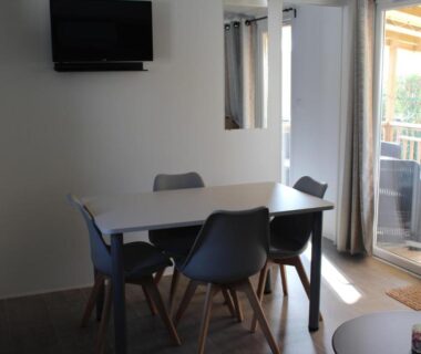 Salle à manger avec table et chaises dans le mobil-home Vos meilleures vacances au Montourey