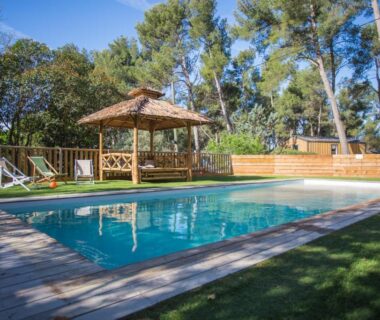 Piscine extérieure entourée de pins avec pergola au Youcamp Village Marseille Provence