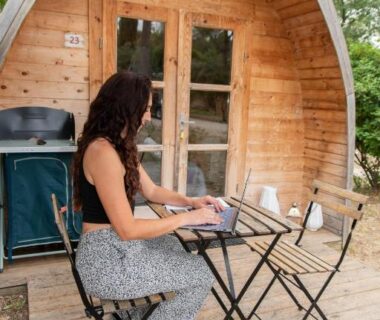Terrasse en bois avec femme travaillant sur ordinateur au Youcamp Village – Marseille Provence