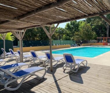 Bord de piscine avec transats et pergola au ZEcamping 2 étoiles