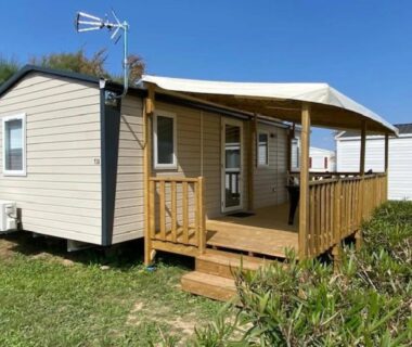 Terrasse couverte et mobil-home sur pelouse au ZEcamping 2 étoiles