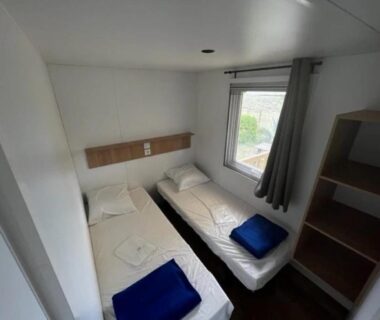 Chambre avec deux lits simples et fenêtre au ZEcamping 2 étoiles