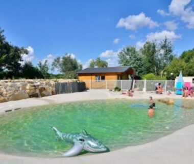 Piscine extérieure en lagon avec gonflable et baigneurs au ZEcamping 3 étoiles