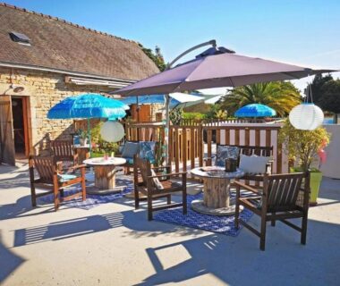 Terrasse extérieure avec parasol et chaises en bois au ZEcamping 3 étoiles Plage à 500m Piscine couverte Dog friendly