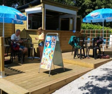 Terrasse snack avec parasols et kiosque au ZEcamping 3 étoiles animations piscine chauffée