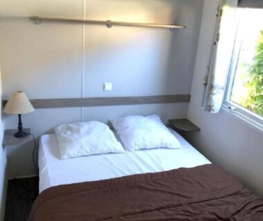 Chambre avec lit double lampe et fenêtre au ZEcamping 3 étoiles animaux acceptés équitation pataugeoire
