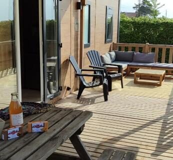Terrasse en bois avec table et fauteuils au ZEcamping 3 étoiles animaux acceptés sauna piscine couverte