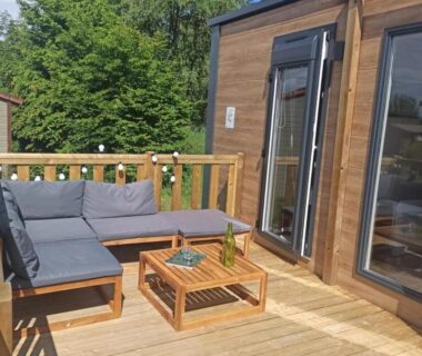 Terrasse en bois avec canapé et table basse au ZEcamping 3 étoiles animaux acceptés sauna piscine couverte