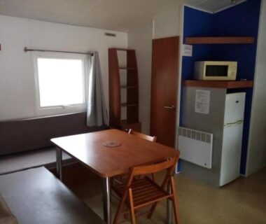 Séjour avec table et coin cuisine dans le mobil-home ZEcamping 3 étoiles animé avec club enfant toboggans restaurant et piscine