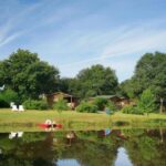 Étang et chalets en bois au bord du camping ZEcamping 3 étoiles animé pet friendly familial piscine chauffée