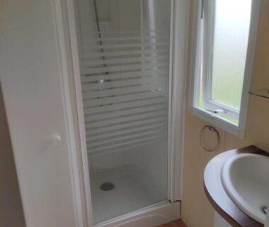 Salle de bain avec cabine de douche et lavabo dans le mobile home ZEcamping 3 étoiles