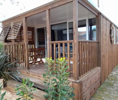Terrasse en bois avec table et chaises au ZEcamping 3 étoiles avec piscine chauffée bar et restaurant