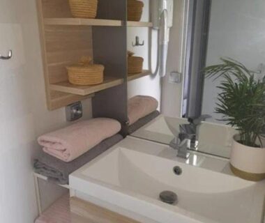Salle de bain avec lavabo et étagères du ZEcamping 3 étoiles avec piscine chauffée – bar et restaurant
