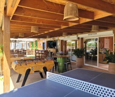 Terrasse couverte avec table de ping-pong et babyfoot au bar du ZEcamping 3 étoiles avec piscine chauffée