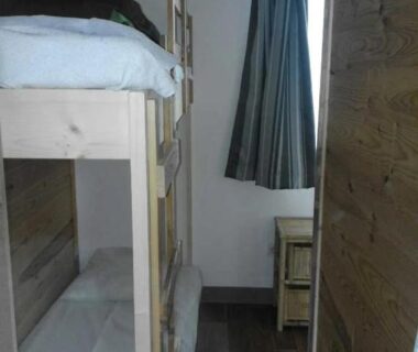 Chambre avec lits superposés en bois et fenêtre dans le ZEcamping 3 étoiles avec piscine et pataugeoire