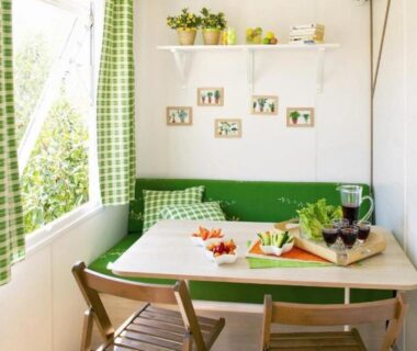 Coin repas avec banquette verte et table dressée au ZEcamping 3 étoiles bord de Loire proximité directe des châteaux