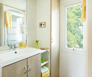 Salle de bain avec lavabo et fenêtre au ZEcamping 3 étoiles bord de Loire