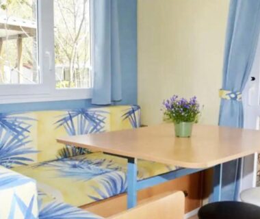 Coin repas intérieur avec banquette et table dans le mobil-home ZEcamping 3 étoiles chiens acceptés piscine bar et restaurant