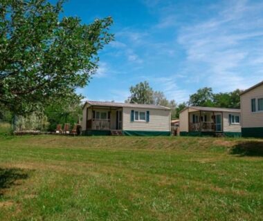Prairie avec mobil-homes et arbres au ZEcamping 3 étoiles chiens acceptés piscine en bord de rivière avec Canoë