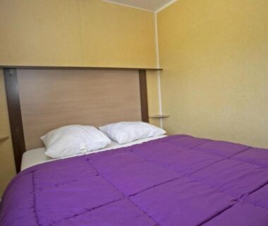 Chambre avec lit double et couette violette au ZEcamping 3 étoiles chiens acceptés piscine en bord de rivière avec Canoë