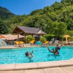 Piscine extérieure chauffée avec enfants et transats au camping ZEcamping 3 étoiles