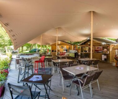 Terrasse couverte avec tables et bar au ZEcamping 3 étoiles club enfant équitation piscine chauffée