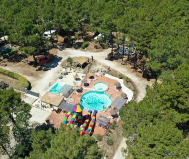 Vue aérienne de la piscine centrale et de l'aire de jeux au ZEcamping 3 étoiles familial