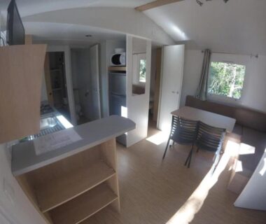 Intérieur de mobil-home avec kitchenette et coin repas au ZEcamping 3 étoiles familial