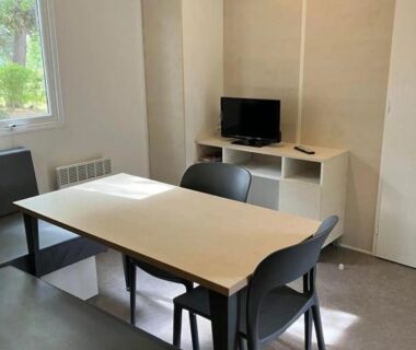 Intérieur avec table et télévision dans le mobil home du ZEcamping 3 étoiles